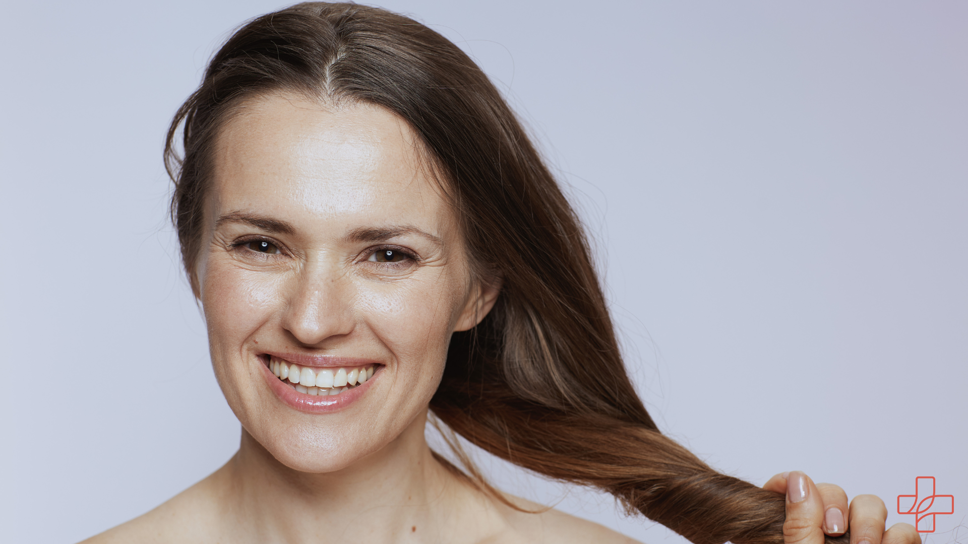 Frau lacht und macht ihre Haare zu einem Zopf Hypogen Care